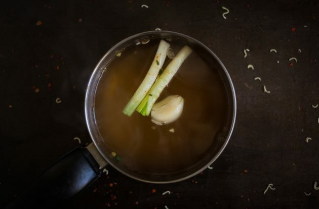Πώς να φτιάξετε σπιτικό ramen: Βράστε το απόθεμα και προσθέστε μια σκελίδα σκόρδο, αποφλοιωμένο τζίντζερ και μίσχους πράσινου κρεμμυδιού