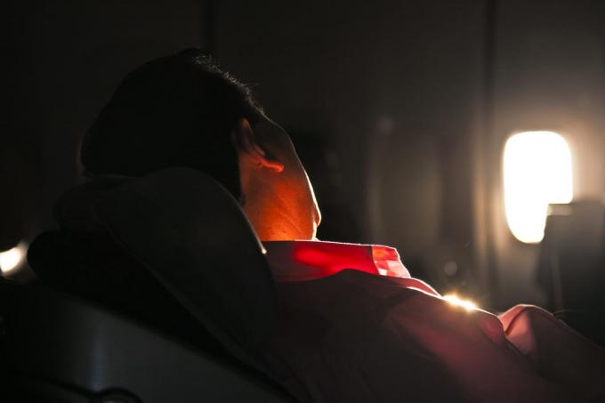 ο άνθρωπος κοιμάται στο κάθισμα του αεροσκάφους στην ανατολή