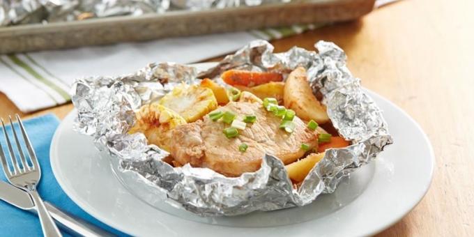 Χοιρινό με πατάτες και το καλαμπόκι σε αλουμινόχαρτο στο φούρνο